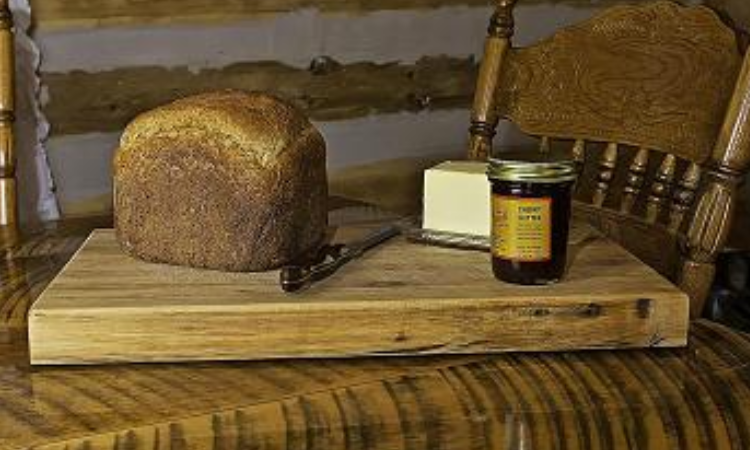 A loaf of bread and jam on a table.