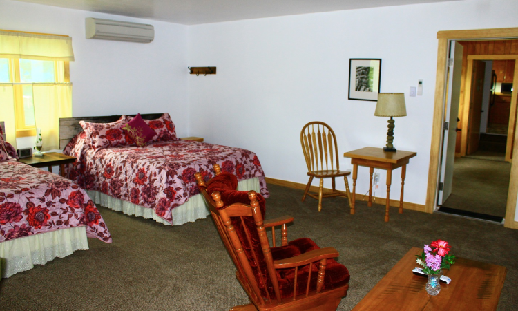 A bedroom with a bed, chair and table.