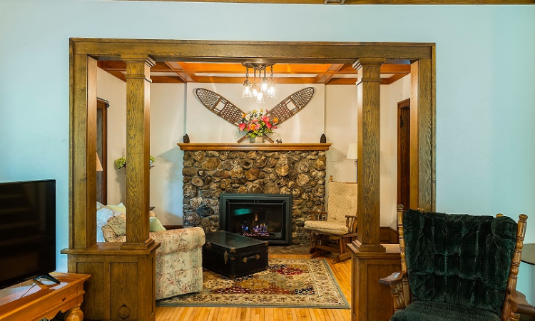 A living room with a fireplace and wooden floors