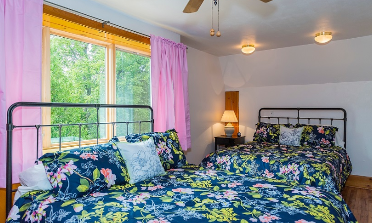 A bedroom with two beds and a window.