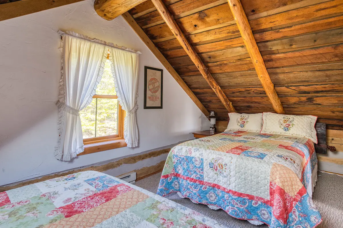 A bedroom with two beds and a window.