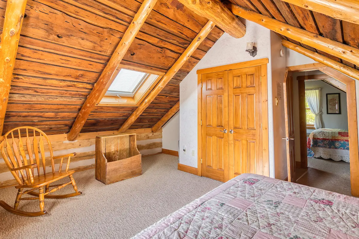 A bedroom with a bed, dresser and window in it.