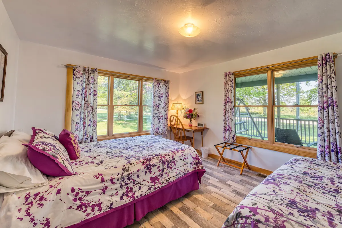 A bedroom with two beds and a window.