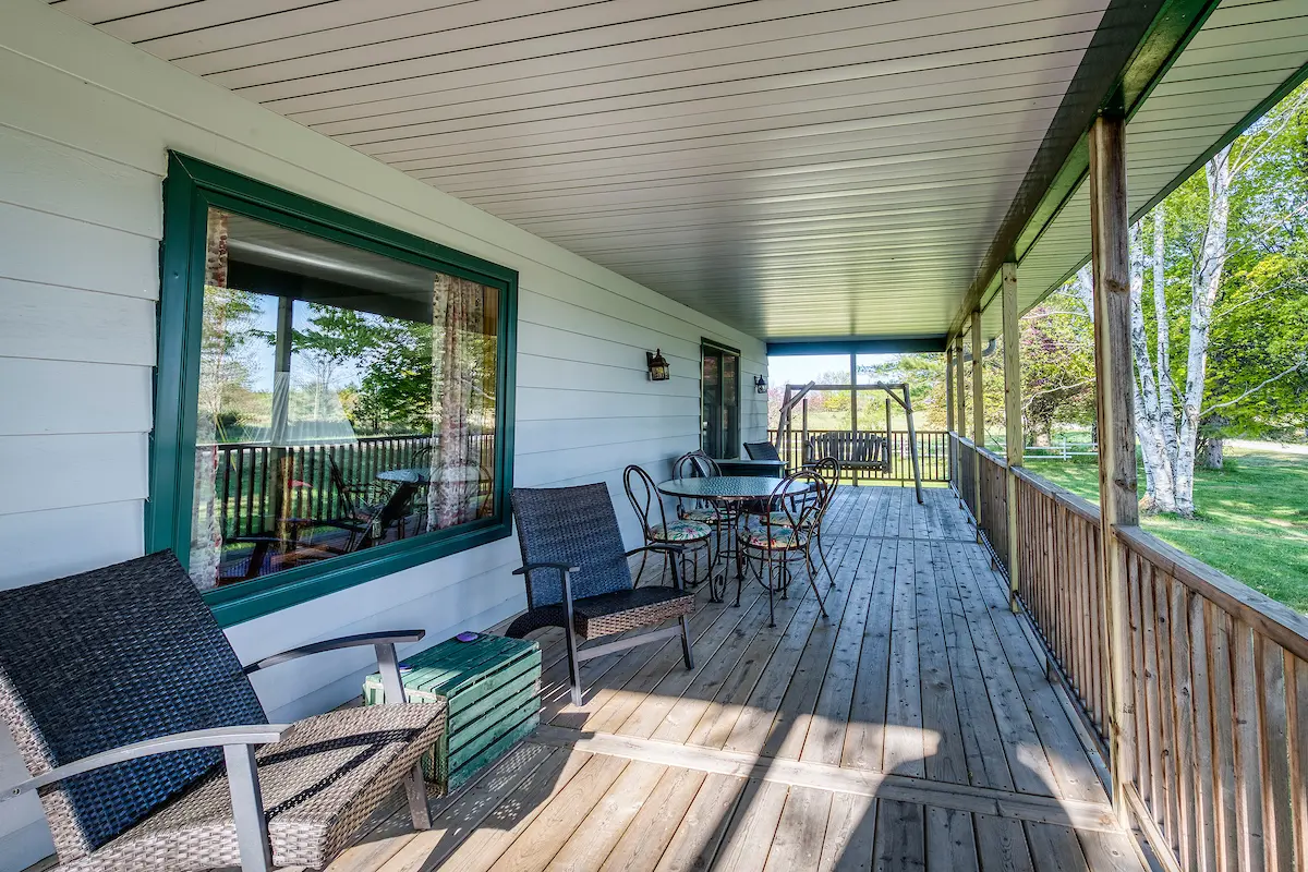 A porch with chairs and tables on it