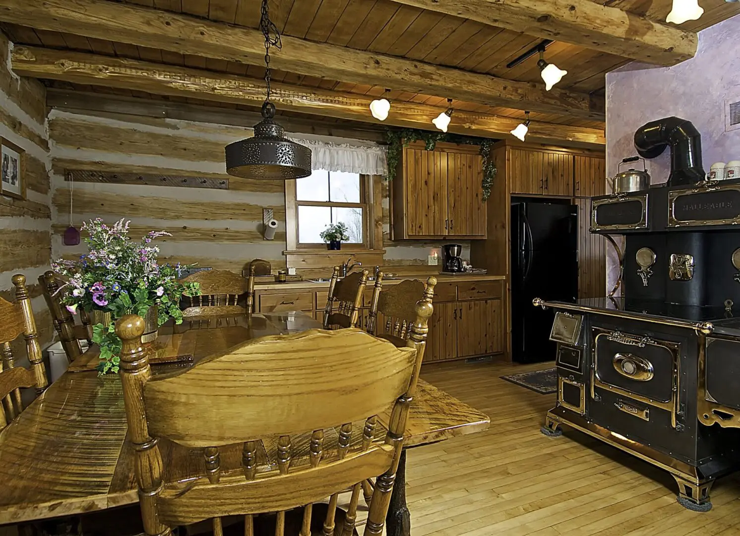 A kitchen with wood floors and wooden cabinets.